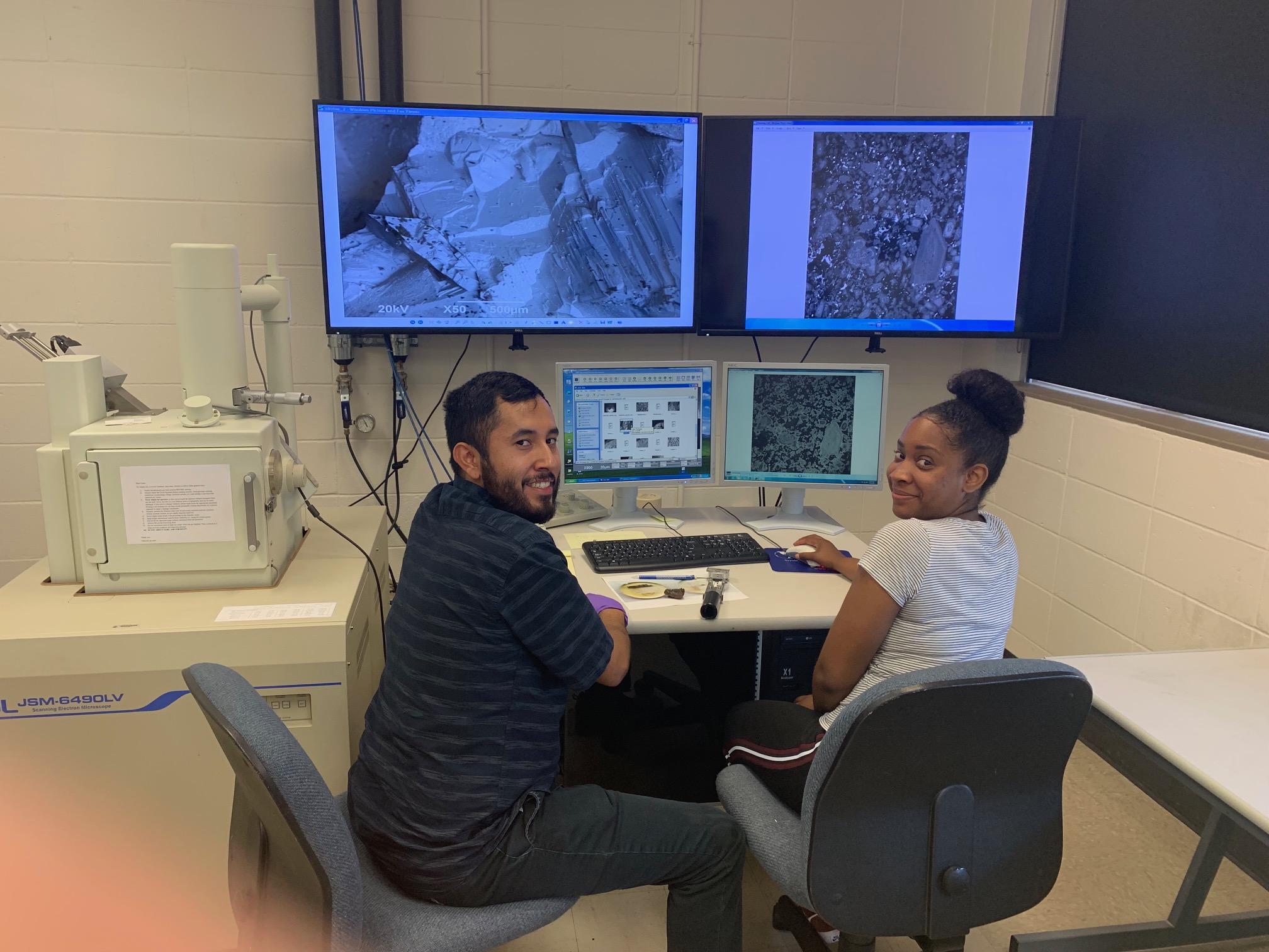 Two graduate students infront of a computer workstation